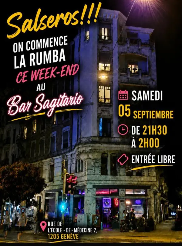 Photo nocturne de l'immeuble d'angle du Bar Sagitario, avec en lettres jaunes et roses l'annonce de la rumba du samedi 5 septembre de 21h30 à 2h, entrée libre.